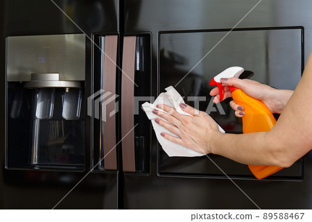 Women hands cleaning the Refrigerator at home kitchen, for corona virus or Covid-19 protection. Home Cleaning service concept. 89588467