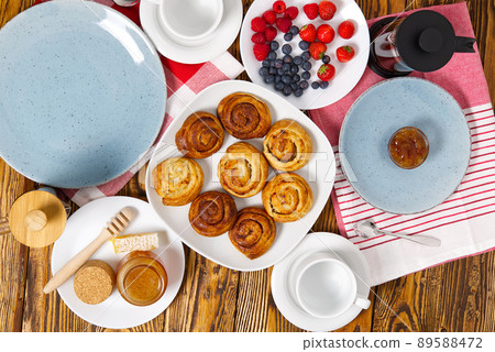 breakfast in the village fresh rolls, coffee, berries and honey laid out on an old brown wooden table. breakfast in the village fresh rolls, coffee, berries and honey laid out on an old brown wooden table. 89588472