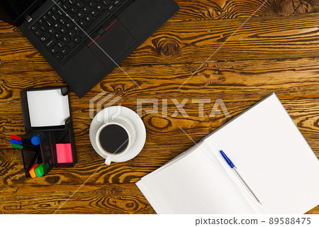 Laptop with cup of coffee on old brown wooden table. Top view to Notebook with cup of fresh coffee in home office in village. 89588475