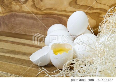 White chicken eggs and broken eggs on wooden board or table. White chicken eggs and broken eggs on wooden board or table. 89588482