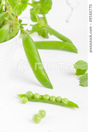 Fresh organic raw green peas pods in a bowl with peas nd plants leaves on white background. Healthy bean protein Fresh organic raw green peas pods in a bowl with peas nd plants leaves on white background. Healthy bean protein 89588770