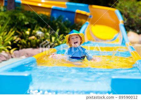 Kids on water slide in aqua park. Summer vacation 89590012
