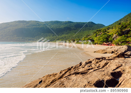 Beach with fog, rocks and ocean in sunny day. Holiday banner with tropical beach Beach with fog, rocks and ocean in sunny day. Holiday banner with tropical beach 89590998