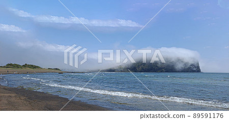 Seongsan Ilchulbong Peak covered with sea fog seen from Gwangchigi Beach after a spring rain 89591176