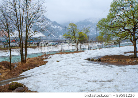 View from the snow-melted Uono River Shinbenbashi, near the Yuzawa IC on the Kan-Etsu Expressway, remaining snow, early spring scenery 89591226