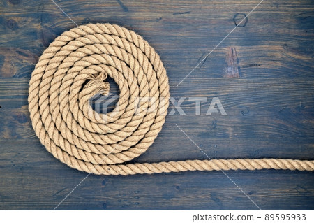Braided natural jute rope over a rustic wood Braided natural jute rope over a rustic wood 89595933