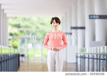 Business woman standing in the office corridor Business woman standing in the office corridor 89596306