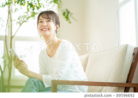 A woman who operates a smartphone, a smartphone at home 89596692