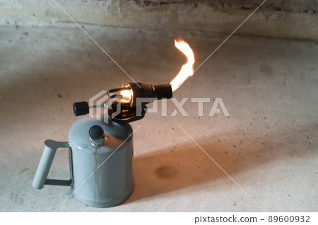 Gasoline blowtorch with a burning fire, the use of a blowtorch in construction. 89600932