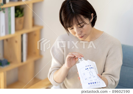 A woman taking medicine out of a medicine bag 89602590