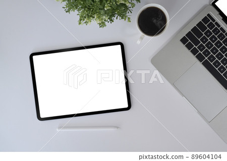 Modern workplace with digital tablet, computer laptop and coffee cup on white table. 89604104