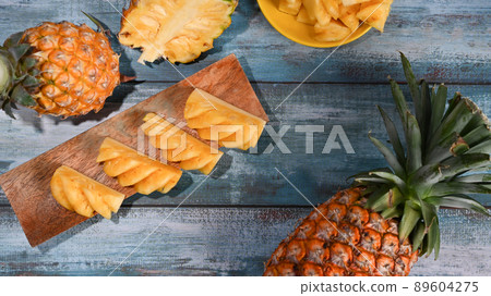 Fresh ripe sliced pineapple on wooden plate. Tropical fruits, summer concept. Fresh ripe sliced pineapple on wooden plate. Tropical fruits, summer concept. 89604275