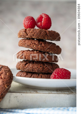 Oatmeal cookies with raspberries on bright background. Oatmeal cookies with raspberries on bright background. 89604864