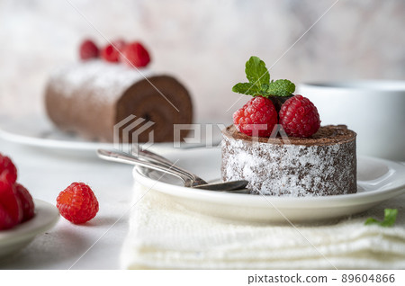 Slice of chocolate roll cake or swiss dessert cake with raspberries. Slice of chocolate roll cake or swiss dessert cake with raspberries. 89604866