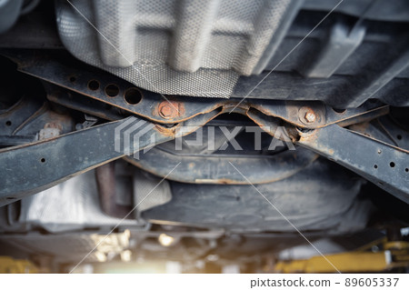 Close-up detail view of bottom car part with rusty broken suspension arm part need replacemant service or maintenance. Vehicle chassis stain warranty repair. Automotive mechanic industrial backround 89605337