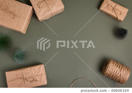 Celebratory Christmas and New Year's holidays background. Gift boxes wrapped craft paper with twine , recycling present on green background Celebratory Christmas and New Year's holidays background. Gift boxes wrapped craft paper with twine , recycling present on green background 89606164