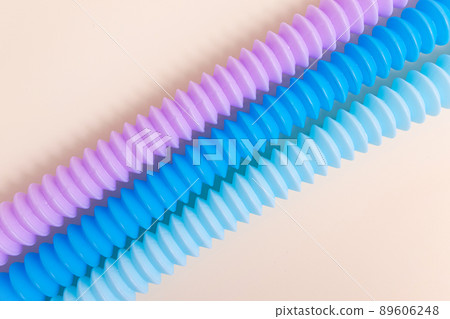 Trendy kids toys pastel colorful pop-tube on beige background. Set of forms and colors corrugated pipe and anti stressing, relaxation fidget finger toys. Trendy kids toys pastel colorful pop-tube on beige background. Set of forms and colors corrugated pipe and anti stressing, relaxation fidget finger toys. 89606248