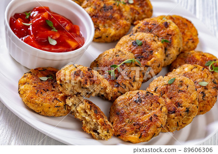 cauliflower patties on plate with tomato sauce 89606306