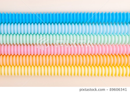Trendy kids toys pastel colorful pop-tube on beige background. Set of forms and colors corrugated pipe and anti stressing, relaxation fidget finger toys. Trendy kids toys pastel colorful pop-tube on beige background. Set of forms and colors corrugated pipe and anti stressing, relaxation fidget finger toys. 89606341