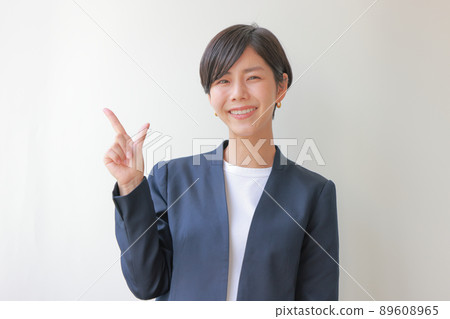 Navy jacket woman pointing diagonally upward 1 89608965