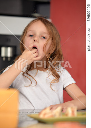 Cute smiling little girl with sushi on white background. Child girl eating sushi and rolls - commercial concept. 89609406