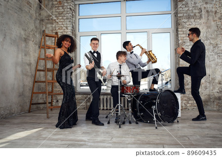 Young international musicians, a band performing on the loft stage. The concept of music, hobby, festival. Inspiration creativity. 89609435