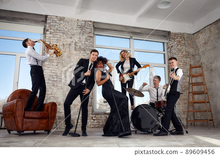 Young international musicians, a band performing on the loft stage. The concept of music, hobby, festival. Inspiration creativity. Young international musicians, a band performing on the loft stage. The concept of music, hobby, festival. Inspiration creativity. 89609456