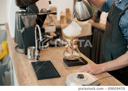 Close up of barista pouring water to make coffee using manual drip brewer 89609459