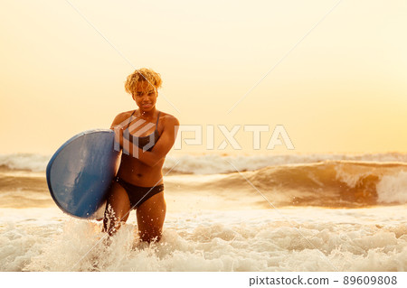 african american surfer girl in water enjoying sunset african american surfer girl in water enjoying sunset 89609808