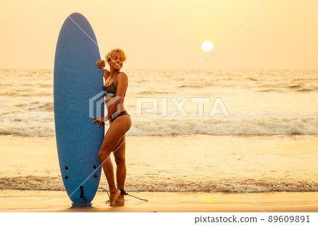 african american surfer girl in water enjoying sunset 89609891