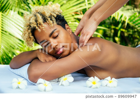 brazilian woman getting back and shoulders massaging in outdoor spa Ayurveda centre in India green tropical background 89609947