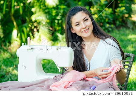 indian female sewing outdoors in summer park indian female sewing outdoors in summer park 89610051