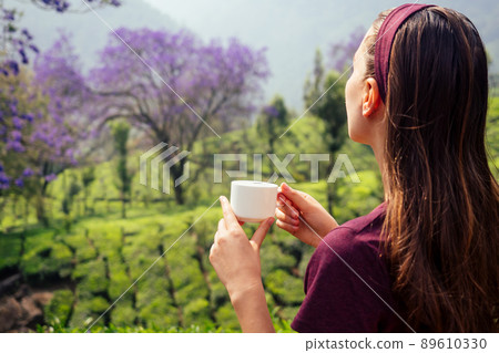 tea cup in female hands backgrounds of mountains with green plant morning in India Kerala Munnar tea cup in female hands backgrounds of mountains with green plant morning in India Kerala Munnar 89610330