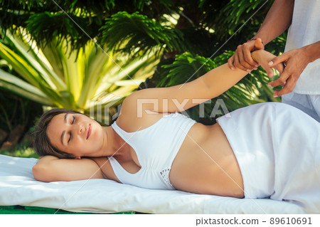 outdoor tropics beach spa centre.pregnant woman getting relax massage in tropical garden 89610691