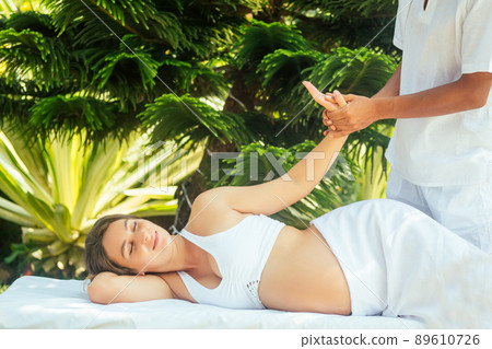 outdoor tropics beach spa centre.pregnant woman getting relax massage in tropical garden 89610726