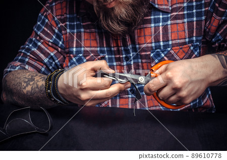 Man working with leather being keen on his buisness Man working with leather being keen on his buisness 89610778