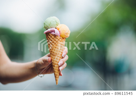 Woman holding delicious colorful ice cream Woman holding delicious colorful ice cream 89611545