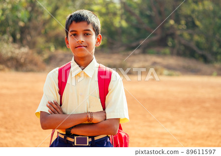 indian smart boy arms crossed looking at camera in backyard indian smart boy arms crossed looking at camera in backyard 89611597
