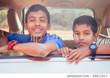two indian boys ready to go to school on the car 89611613