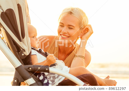 beautiful mother and her cute child walking before going to sleep on the beach 89612297