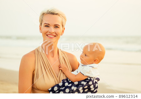 breast-feeding on breast-feeding concept. beautiful woman with baby on the summer beach at sunset 89612314