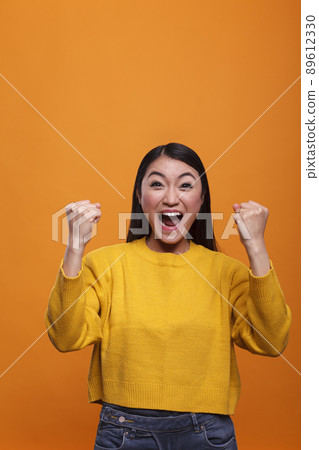 Overjoyed excited confident beautiful woman model celebrating in triumph successful results. Strong optimistic young adult asian woman laughing heartily while winning video game. Overjoyed excited confident beautiful woman model celebrating in triumph successful results. Strong optimistic young adult asian woman laughing heartily while winning video game. 89612330