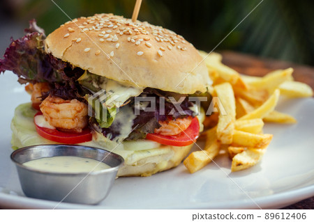 prawns burger and french fry on table tropical sea ,palms tree and beach background 89612406
