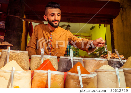 indian sallerman showing his small shop on arambol goa market 89612729