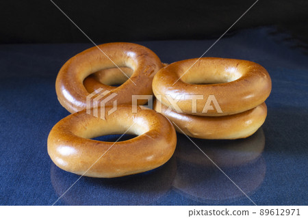 Round bagel on a blue table with reflection Round bagel on a blue table with reflection 89612971