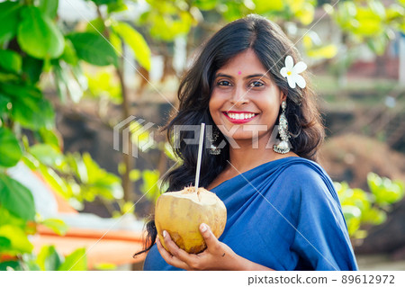 Happy indian woman coconut drink on the tropical beach.travel medical insurance concept Happy indian woman coconut drink on the tropical beach.travel medical insurance concept 89612972