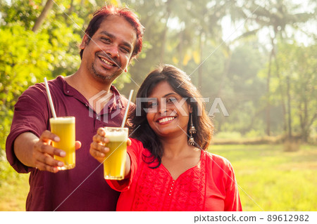 happy indian family holding glass of fresh cane juice with eco metal tube. Love to health and save planet . recyclable concept 89612982