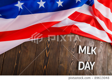 the word MLK day laid with silver metal letters on wooden surface with crumpled USA flag at upper side the word MLK day laid with silver metal letters on wooden surface with crumpled USA flag at upper side 89613048