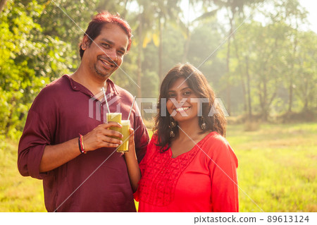 happy indian family holding glass of fresh cane juice with eco metal tube. Love to health and save planet . recyclable concept happy indian family holding glass of fresh cane juice with eco metal tube. Love to health and save planet . recyclable concept 89613124