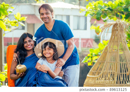 using eco metal recyclable tube.happy asian parents and cute girl enjoying summer vacation in Goa beach , drinking coconut water.travel medical insurance concept using eco metal recyclable tube.happy asian parents and cute girl enjoying summer vacation in Goa beach , drinking coconut water.travel medical insurance concept 89613125